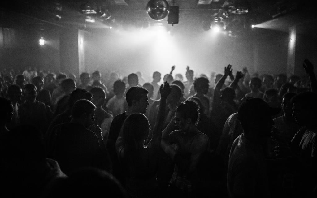 Packed dance floor silhouettes mid-move